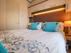 A bedroom with a double bed with blue pillows and patterned bedding at The Boathouse in St Leonards-On-Sea