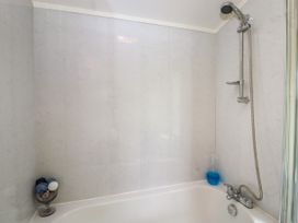 A bathtub with a showerhead and bottles on the edge at The Boathouse in St Leonards-On-Sea