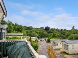 A view of a residential area with multiple mobile homes along a road and trees in the background at The Boathouse in St Leonards-On-Sea
