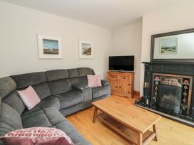 A living room with a sofa, coffee table, and television at The Skating Rock in Bunane near Kenmare, County Kerry