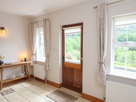 An entrance hall with a table and window curtains at The Skating Rock in Bunane near Kenmare, County Kerry