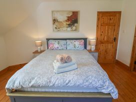 A bedroom with a bed and bedside table at The Skating Rock in Bunane near Kenmare, County Kerry