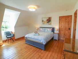 A bedroom with a bed and chair at The Skating Rock in Bunane near Kenmare, County Kerry