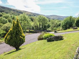A view of a garden with trees and a gravel path at The Skating Rock in Bunane near Kenmare, County Kerry