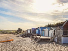 Beach huts on sand at Northwood Lodge Llanbedrog