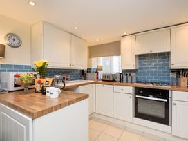 A kitchen with cabinets and appliances at Dolls Cottage Looe