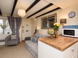 A living room with a sofa and armchair at Dolls Cottage in Looe