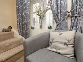A living room with a sofa and curtains at Dolls Cottage in Looe