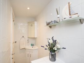 A bathroom with a mirror and sink at Dolls Cottage in Looe