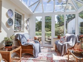 A conservatory with sofas and plants at Temple House in Goonhavern