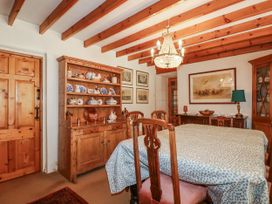 A dining room with a table and sideboard at Temple House in Goonhavern