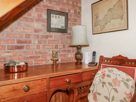 A study area with a desk, lamp, and telephone at Temple House in Goonhavern