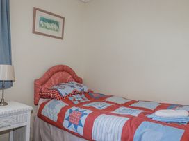 A bedroom with a single bed and a lamp at Temple House in Goonhavern