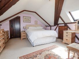 A bedroom with a bed and nightstands at Temple House in Goonhavern