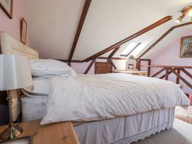 A bedroom with a bed and nightstand at Temple House in Goonhavern