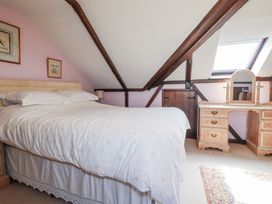 A bedroom with a bed and dressing table at Temple House in Goonhavern