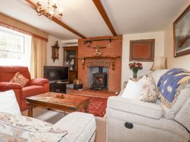 A living room with a fireplace and sofa at Temple House in Goonhavern