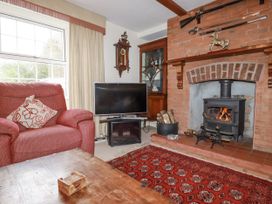 A living room with a sofa and a television at Temple House in Goonhavern