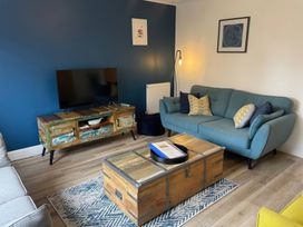 A living room with a television, sofa and coffee table at Plain Sailing Weymouth