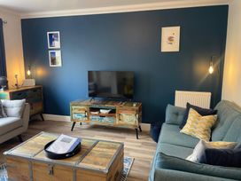 A living room with a television and sofa at Plain Sailing in Weymouth