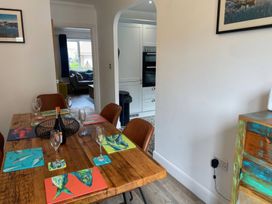 A dining room with a wooden table and chairs at Plain Sailing in Weymouth