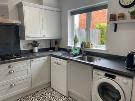 A kitchen featuring a sink, dishwasher, and stove at Plain Sailing in Weymouth