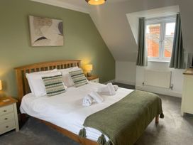 A bedroom with a bed and side tables at Plain Sailing in Weymouth