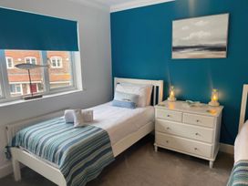 A bedroom with two beds and a chest of drawers at Plain Sailing in Weymouth