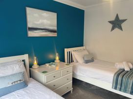 A bedroom with two beds and decorative items at Plain Sailing in Weymouth