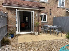 A patio area with a table and chairs at Plain Sailing in Weymouth