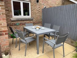 An outdoor dining area with a table and chairs at Plain Sailing in Weymouth