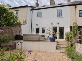 A garden with a seating area and steps at Belfry Cottage in Colyton