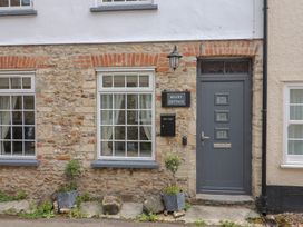 A front view of a cottage with stone walls and windows at Belfry Cottage in Colyton