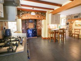 A kitchen with a stove and dining area at Parrog Stores in Parrog near Newport, Pembrokeshire