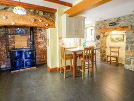 A kitchen with a stove and bar stools at Parrog Stores Parrog near Newport, Pembrokeshire