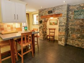 A kitchen with bar stools and stone wall at Parrog Stores near Newport, Pembrokeshire