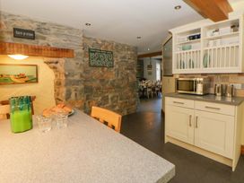 A kitchen with stone walls and a table at Parrog Stores Parrog near Newport, Pembrokeshire