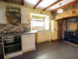 A kitchen with cabinets, stove, and sink at Parrog Stores near Newport, Pembrokeshire