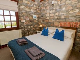 A bedroom with a bed and stone walls at Parrog Stores Parrog near Newport, Pembrokeshire