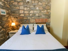 A bedroom with a bed and lamp at Parrog Stores near Newport, Pembrokeshire