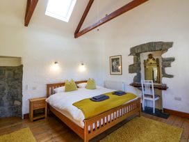 A bedroom with a bed and a mirror at Parrog Stores in Parrog near Newport, Pembrokeshire