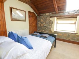 A bedroom with a bed and towels at Parrog Stores near Newport, Pembrokeshire