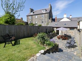 A garden with a bench and dining table at Parrog Stores in Parrog near Newport, Pembrokeshire