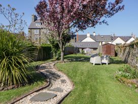 A garden with chairs and a tree at Parrog Stores in Parrog near Newport, Pembrokeshire