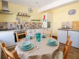 A kitchen with a dining table set for four at Parrog Bach in Parrog near Newport, Pembrokeshire