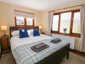 A bedroom with a bed and nightstand at Parrog Bach in Parrog near Newport, Pembrokeshire
