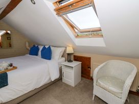 A bedroom with a bed and chair at Parrog Bach, Parrog near Newport, Pembrokeshire