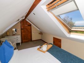 A bedroom with a bed and a view of the sea at Parrog Bach Parrog near Newport, Pembrokeshire