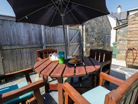 An outdoor seating area with a table and chairs at Parrog Bach in Parrog near Newport, Pembrokeshire