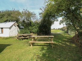 A garden with a table and benches near a shed at Llainorfa in Maenygroes near New Quay